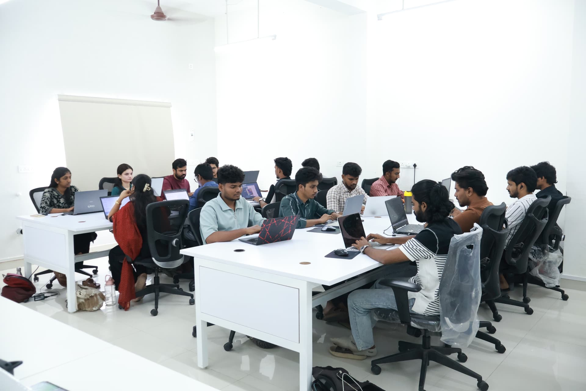 Students and mentors collaborating in a modern innovation workspace
